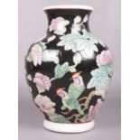 A large Chinese baluster shaped famille noir vase, decorated with birds and flowers. 30cm.