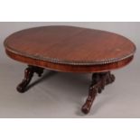 A Victorian carved mahogany wind out table raised on twin scrolled supports.