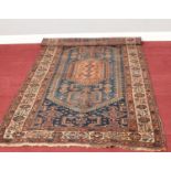 A blue ground Aztec style rug, with central medallion 102cm x 182cm