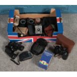 A box of cameras and binoculars. Including Ross London binoculars, box cameras, viewers, flashes,