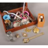 A wooden case containing an assortment of watches. Includes Accurist, mechanical pocket watch,