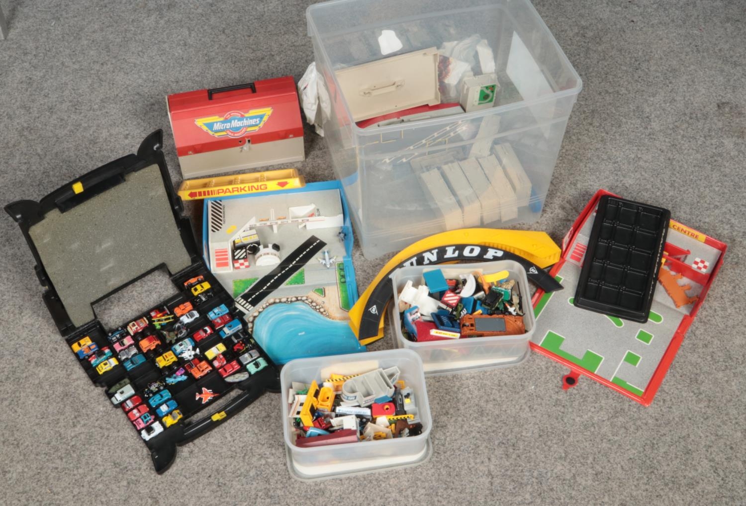 A box of Micro Machine cars and platforms.