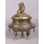 A Chinese bronze lidded censor. With temple lion finial and decorated with animals and flowers.