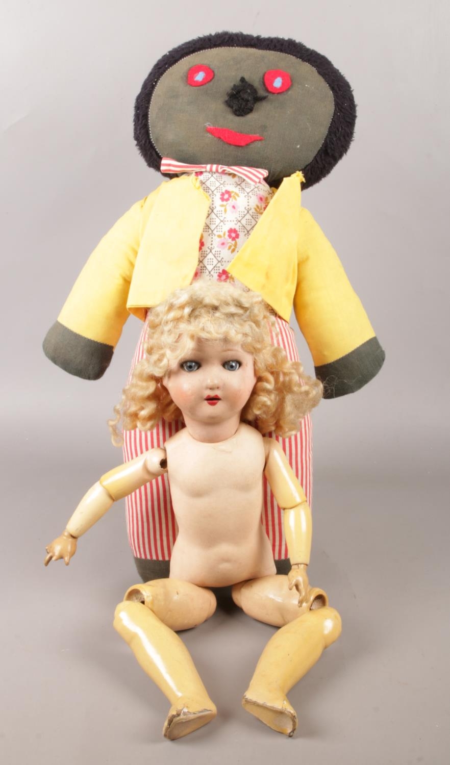 A vintage jointed doll, along with a soft toy.