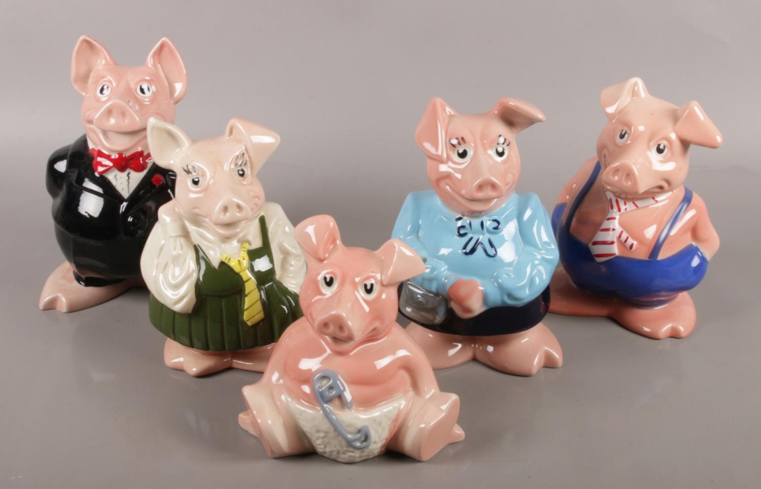 Five ceramic NatWest pigs.