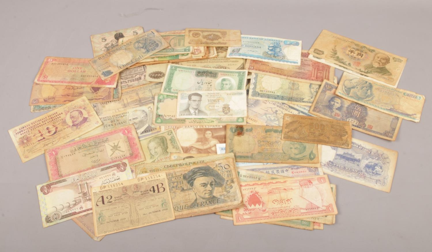A collection of vintage world bank notes. Lire, Yuan, Francs, dollars etc