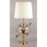 A brass armillary lamp, with cream shade, on turned base. 76cm high. In working order.