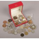 An Omega watch box with contents of coins and badges. Includes 1799 halfpenny, 1951 crown etc.