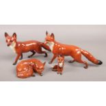 Four Beswick porcelain figures of foxes. Leg repaired to two.