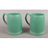 A pair of Wedgwood Keith Murray ceramic tankards in matt green. Signed to the base. Slight red