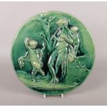 A circular glazed pottery wall plaque, depicting classical scenes, possibly Burmantofts.