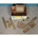 A box of metalwares. Including ornate brass push plates, small metal wood plane, lion mask door