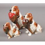 A set of three Royal Doulton spaniels with pheasants, HN1028. Repair to tail of largest dog.