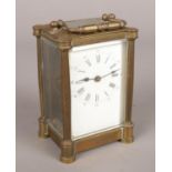 An antique brass carriage clock, white enamel dial. Chips to glass.