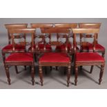 A set of seven Regency mahogany dining chairs, including one carver. With red upholstered seats