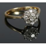 An 18ct Gold and Diamond cluster ring, with large central stone surrounded by eight smaller