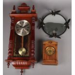 A mahogany 31 day wall clock along with a small mantel clock and a framed convex mirror.