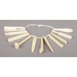 A child's ivory teething ring, with twelve individual teethers, including cricket bat, hammer and