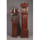 Two mahogany longcase clock cases, with brass and carved detailing. Tallest example 223cm high.