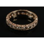 A 9ct gold and white paste eternity ring. Size P1/2. Assayed in Birmingham. Total weight: 2.58g.