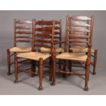 A set of five oak framed ladder back rush seat dining chairs, including one carver.