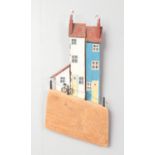 A Jo Perry drift wood wall hanging. Comprising of wood painted houses. Signed to the reverse. H:40cm