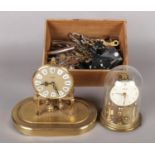 Two Kundo torsion clocks, together with a series of clock parts and keys. Largest torsion clock is