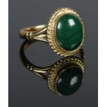 An 18ct Gold and malachite ring, with rope twist border surrounding the stone. Size H. Total weight: