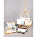 An assortment of artist's materials. To include a Mont Marte desk easel, oils, acrylics, artist's