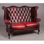 An ox blood deep buttoned studded leather Chesterfield two seat sofa.