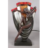 A Tiffany style table lamp, depicting a woman draped in a sheet, in front of stained glass fan