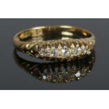 An 18ct Gold and five stone Diamond ring, with pierced bridge. Largest diamond 1/16ct. Size R. Total