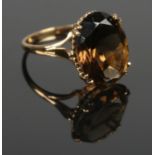 A 9ct gold ring set with a large faceted smoky quartz stone. Height of stone: 17mm. Size O. Total