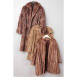 Two vintage fur coats, along with an Astraka faux fur example.