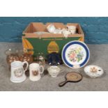 A box of assorted commemorative ware. Glasses, mugs, plates etc