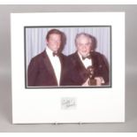 A mounted image of Cubby R. Broccoli & Roger Moore with signature of Cubby Broccoli. (Executive