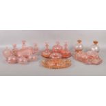 Three pink cut glass dressing table sets. Comprising of candlesticks, trays, frosted glass swan