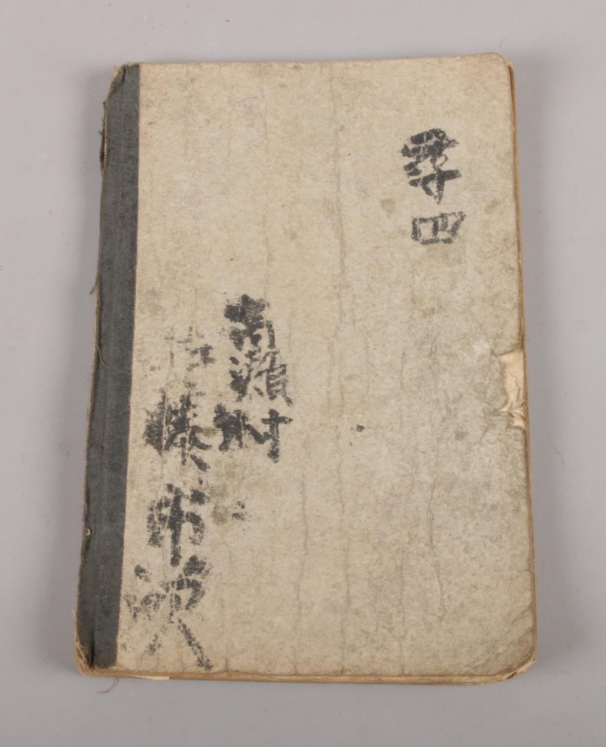 A vintage Japanese book with calligraphy & illustrations.