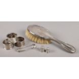 A collection of silver and white metal items. Includes three silver napkin rings, silver backed