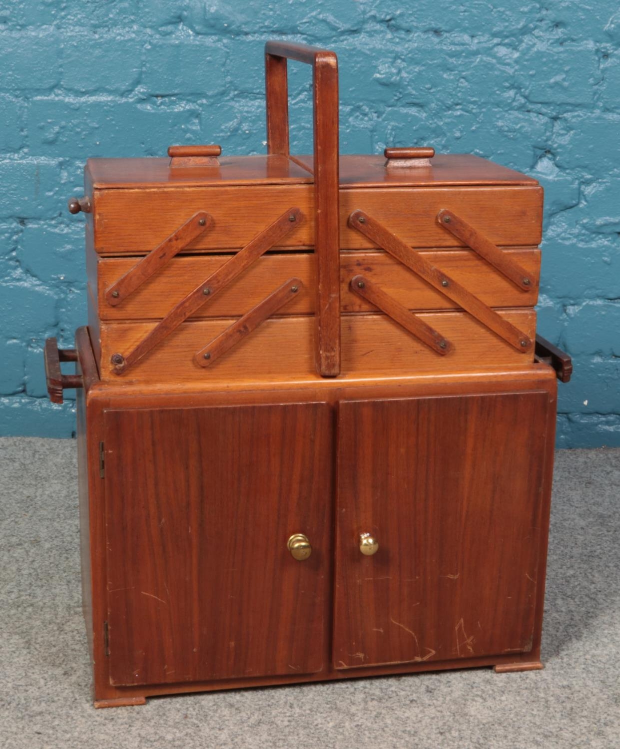 A mid twentieth century mahogany sewing cupboard, with lift-away cantilever box, with contents. 59cm