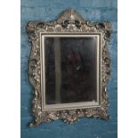 An ornate wall mirror with floral frame. (84cm x 63cm) Minor chips to silvering on frame.