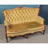 A green deep buttoned upholstered two seat sofa. Decorated with carved frame.