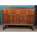 A carved and panelled oak sideboard.