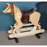 A carved and painted wooden rocking horse on stand.