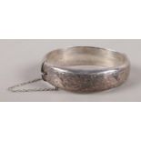 A silver hinged bangle with engraved decoration. Assayed Birmingham 1959. 25g.