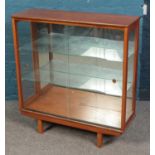 A teak display cabinet with glass sliding doors and mirror interior.