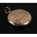A 15ct gold circular locket pendant with engraved floral decoration. Gross weight 9.46g.