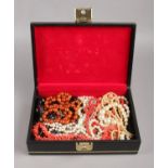 A black jewellery box containing costume jewellery, mainly necklaces.
