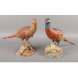 A pair of Spode Pheasants; Cock and Hen, both perched on logs. Cock Pheasant has become detached