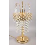 A modern gold coloured table lamp, with a chandelier droplet style shade. In working order.